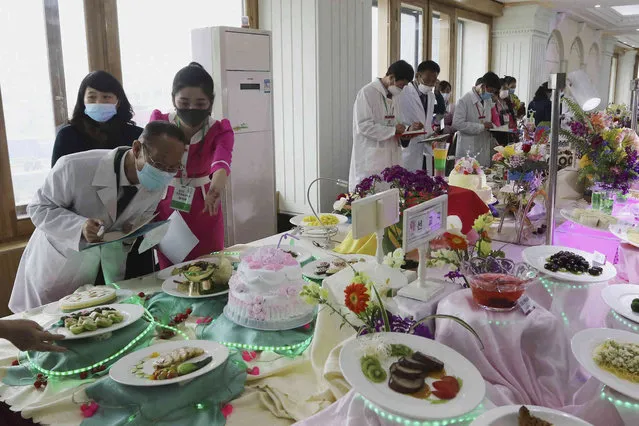 Participants look around dishes on display during the 26th Cooking Festival at the Pyongyang Noodle House in Pyongyang, North Korea, Tuesday, April 11, 2023. The festival was held on the Day of the Sun public holiday to mark the birth anniversary of the country's late leader Kim Il Sung. (Photo by Jon Chol Jin/AP Photo)