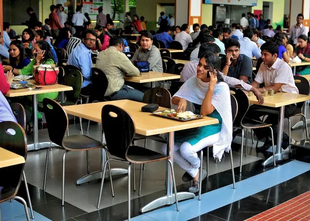 An employee speaks on a mobile phone as she eats her lunch at the cafeteria in the Infosys campus in Bengaluru, India, September 23, 2014. (Photo by Abhishek N. Chinnappa/Reuters)