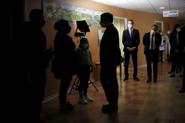 French President Emmanuel Macron, center silhouetted, visits a child psychiatry department at Reims hospital, eastern France, to discuss the psychological impact of the COVID-19 crisis and the lockdown on children and teenagers in France, Wednesday, April 14, 2021. (Photo by Christian Hartmann/Pool via AP Photo)