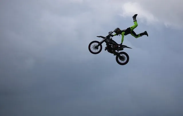 A rider from the Extreme Bike Battle display team performs a stunt as part of the Royal Cheshire County Show near Knutsford, Britain on June 21, 2023. (Photo by Phil Noble/Reuters)
