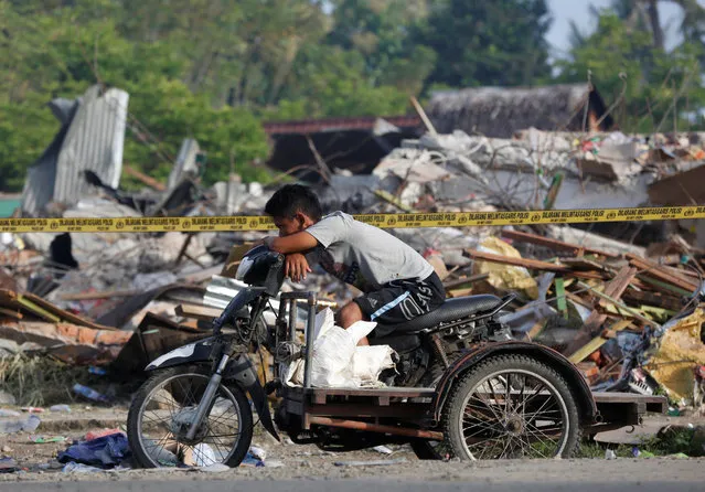 A cart driver rests in front of a building which collapsed following this week's strong earthquake in  Pidie Jaya, Aceh province, Indonesia, December 10, 2016. (Photo by Darren Whiteside/Reuters)