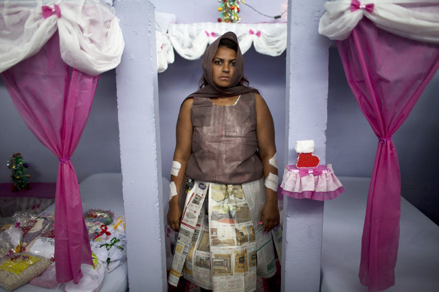 A prisoner waits to perform during the 7th annual Nelson Hungria prison’s Christmas event that includes a cell decorating contest and a skit dramatizing biblical stories, in Rio de Janeiro, Brazil, Thursday, December 15, 2016. Inmates who are serving time for offenses from burglary to homicide, spent weeks decking out the cell blocks with the holiday decorations they created. The inmates used materials they had access to behind bars such as plastic bottles, paper, ground-up Styrofoam and aluminum trays. (Photo by Silvia Izquierdo/AP Photo)