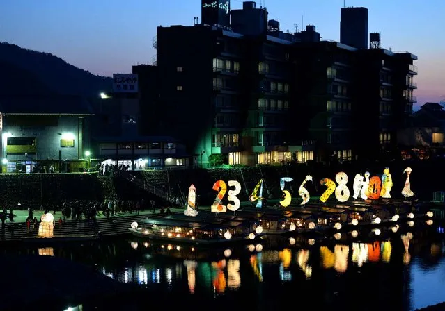 The 13 houseboats loading large paper lanterns of the calendar’s numbers and monkey, this year’s animal symbol flew away on the Nagaragawa River in Gifu Prefecture on December21, 2016. The art event has been held on the winter solstice since 2006. One by One, the house boats illuminating the surface of the river left away down the stream. (Photo by The Yomiuri Shimbun via AP Images)