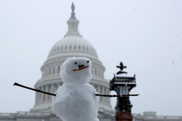 A tiny snowman sits on a ledge in a light snow at the U.S. Capitol in Washington, USA on November 15, 2018. (Photo by Jonathan Ernst/Reuters)