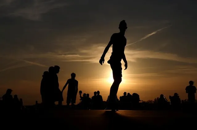 People enjoy the sunset at the Tempelhofer Feld, as the spread of the coronavirus disease (COVID-19) continues, in Berlin, Germany, May 9, 2021. (Photo by Christian Mang/Reuters)