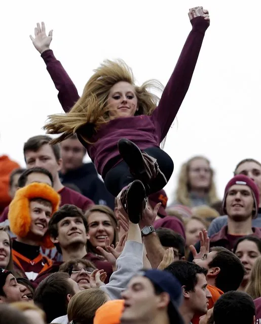 A Virginia Tech fan is tossed in the air to celebrate a touchdown during the first half of a game against Maryland in  Blacksburg, on November 16, 2013. (Photo by Steve Helber/Associated Press)