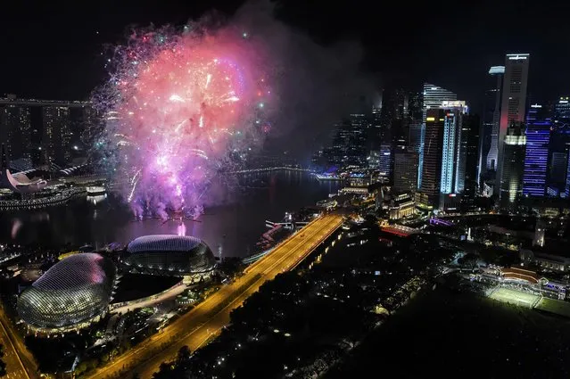 New Year fireworks burst over the Marina Bay skyline in Singapore on January 1, 2017. (Photo by Roslan Rahman/AFP Photo)