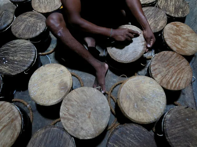 A man scrapes an animal skin on traditional drums at a workshop in Nittambuwa, Sri Lanka November 8, 2016. (Photo by Dinuka Liyanawatte/Reuters)