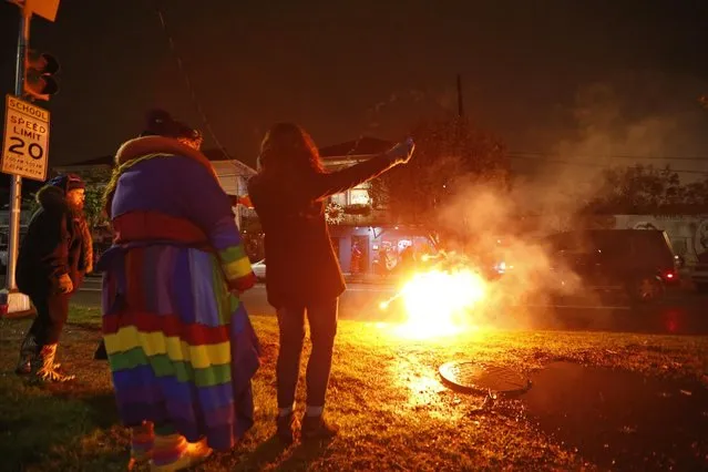 Revelers of the “Societe des Champs Elysee” launch fireworks before boarding the Rampart-St. Claude street car line, which just opened last fall, to commemorate the official start of Mardi Gras season, in New Orleans, Friday, January 6, 2017. (Photo by Gerald Herbert/AP Photo)