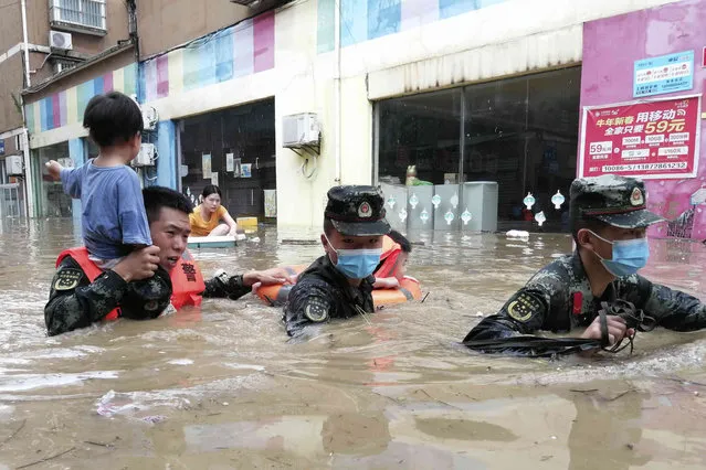 Chinese paramilitary police work to evacuate people trapped in a flooded area in Suizhou in central China's Hubei Province, Thursday, August 12, 2021. Flooding in central China continued to cause havoc in both cities and rural areas, with authorities saying Friday that more than 20 people had been killed and another several were missing. (Photo by Chinatopix via AP Photo)