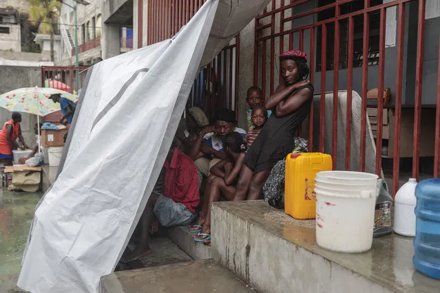 Displaced people stand in the inner courtyard of a school where they are taking refuge due to gang violence, as it rains due to Tropical Storm Franklin in Port-au-Prince, Haiti, Wednesday, August 23, 2023. (Photo by Odelyn Joseph/AP Photo)