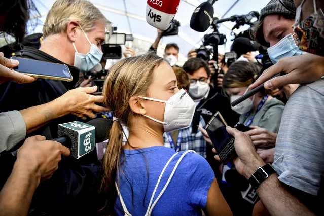 The Swedish climate activist Greta Thunberg is surrounded by members of the media as she arrives for a three-day Youth for Climate summit in Milan, Italy on September 28, 2021. (Photo by Claudio Furlan/LaPresse via AP Photo)
