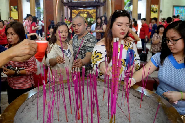 Members of the Chinese community light incense sticks as they offer prayers inside the Seng Guan temple during Chinese Lunar New Year celebrations in Manila's Chinatown, Philippines January 28, 2017. (Photo by Ezra Acayan/Reuters)