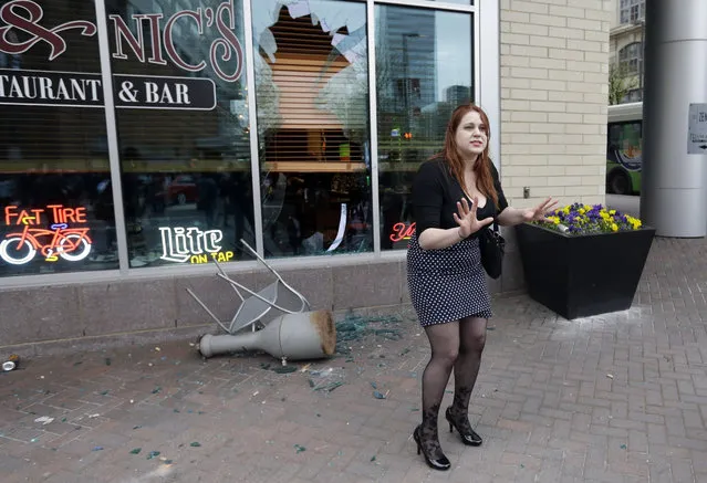 A woman pleads with protestors to stop breaking restaurant windows after a rally for Freddie Gray, Saturday, April 25, 2015, in Baltimore. (Photo by Patrick Semansky/AP Photo)