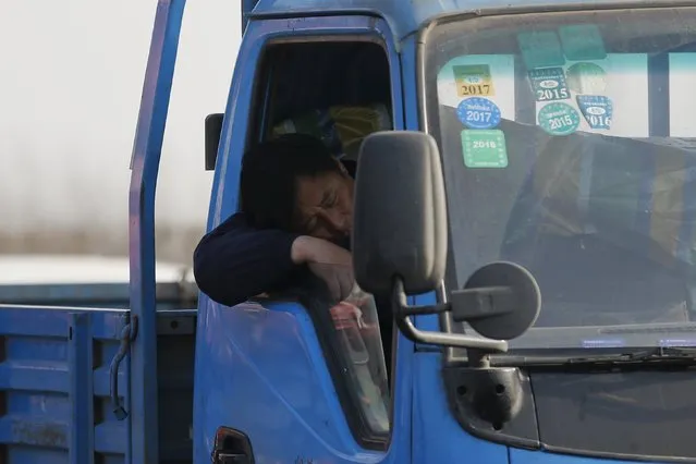 A man takes a nap in a truck as cars stop on Jinji Expressway located between Beijing and Tianjin, in a heavy traffic jam in Tianjin, China, March 2, 2016. (Photo by Kim Kyung-Hoon/Reuters)