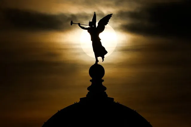 The Sun rises behind an angel on the rooftop of the Dome on the Academy of Arts in central Dresden, Germany, 29 December 2023. Meteorologists predict cloudy weather with temperatures around seven degrees Celsius will continue until the end of the year in the German state of Saxony. (Photo by Filip Singer/EPA)