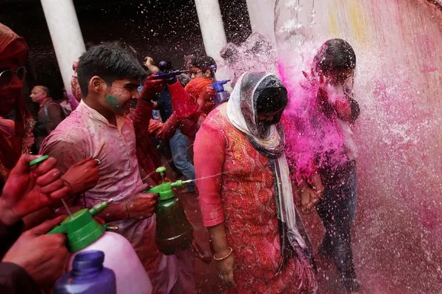 Girls run for cover as boys spray coloured water on them during religious festival of Holi inside a temple in Nandgaon village, in the state of Uttar Pradesh, India, March 16, 2019. (Photo by Adnan Abidi/Reuters)