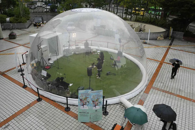 Musicians film their musical performance to upload to the online site for people inside a plastic bubble in Seoul, South Korea, Friday, October 8, 2021. A local foundation for Arts and Culture organizes the event supporting musicians and allowing more people to enjoy concerts amid the coronavirus pandemic. (Photo by Lee Jin-man/AP Photo)
