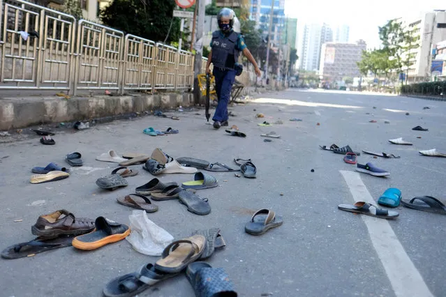 Footwear of protestors lie strewn on a road after clashes with police during a protest over an alleged insult to Islam, outside the country’s main Baitul Mukarram Mosque in Dhaka, Bangladesh, Friday, October 15, 2021. (Photo by Mahmud Hossain Opu/AP Photo)