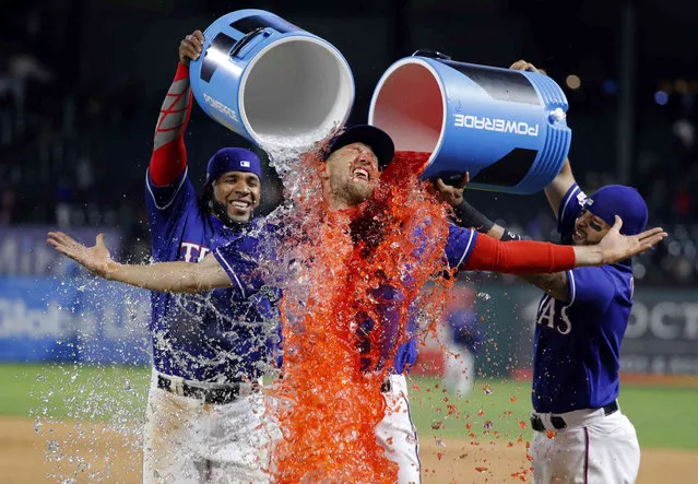 Texas Rangers' Hunter Pence is doused by Elvis Andrus, left, and Rougned Odor, right, following the teams baseball game against the Houston Astros in Arlington, Texas, Wednesday, April 3, 2019. The Rangers won 4-0. (Photo by Tony Gutierrez/AP Photo)