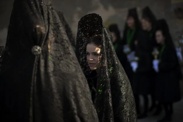 Women wearing the traditional mantilla wait before taking part in the “Procesion Virgen de la Esperanza” brotherhood, during the Holy Week in Zamora, Spain, Thursday, March 24, 2016. (Photo by Emilio Morenatti/AP Photo)