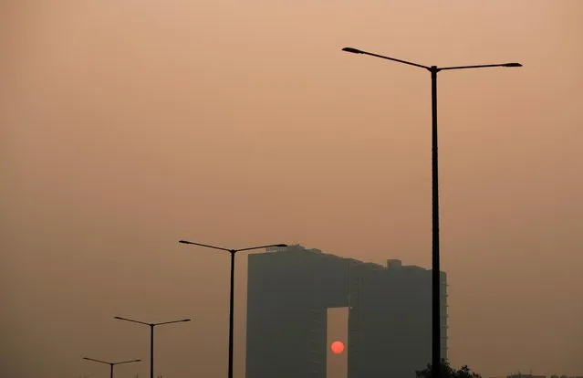An office complex building is seen shrouded in smog in Noida on the outskirts of New Delhi, India, November 15, 2021. India’s Supreme Court has ordered people in New Delhi and surrounding regions to work from home over pollution concerns. (Photo by Adnan Abidi/Reuters)