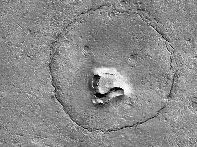 An undated image from NASA's Mars Reconnaissance Orbiter shows hills, craters and a circular fracture pattern on the surface of Mars, in this handout image obtained by Reuters on January 25, 2023. (Photo by NASA/JPL-Caltech/UArizona/Handout via Reuters)