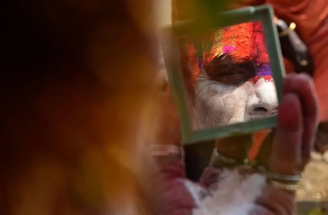 A Hindu sadhu (holy man) smears coloured paste onto his face ahead of the forthcoming Hindu festival of Maha Shivaratri at The Pashupatinath Temple in Kathmandu on February 20, 2017. Hindus mark the Maha Shivratri festival by offering special prayers and fasting, with sadhus arriving at Pashupatinath to take part in the event, which takes place on February 24. (Photo by Prakash Mathema/AFP Photo)