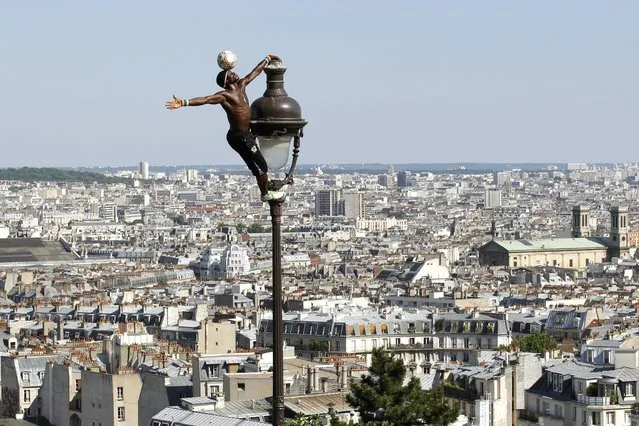 Soccer freestyler Iya Traore from Guinea performs with a ball in the gardens of Montmartre's Sacre Coeur Basilica in Paris, France, one of the Olympics 2024 bid cities, July 4, 2010. (Photo by Benoit Tessier/Reuters)