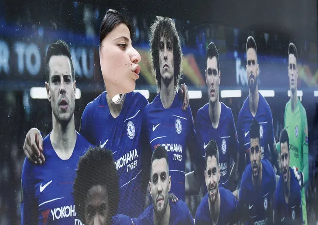 A woman poses with a poster of the Chelsea team in a fan zone on the eve of the Europa League final soccer match between Arsenal and Chelsea in Baku, Azerbaijan, Tuesday, May 28, 2019. (Photo by Dmitri Lovetsky/AP Photo)