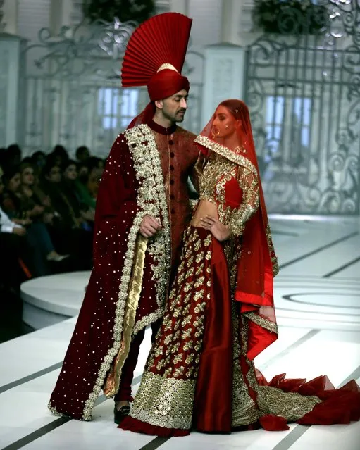 Models present creations during Bridal Couture Week, in Lahore, Pakistan, Saturday, December 11, 2021. Twenty-eight designers and retail brands are showcasing their latest bridal collections in the three-day event. (Photo by K.M. Chaudary/AP Photo)