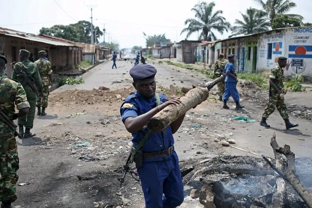 Policemen and soldiers clear a barricade during a protest against President Pierre Nkurunziza and his bid for a third term in Bujumbura, Burundi, May 25, 2015. (Photo by Goran Tomasevic/Reuters)