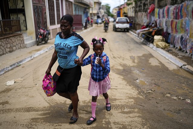 A child sips on a drink after she was picked up from school, in Cap-Haitien, Haiti, April 17, 2024. (Photo by Ramon Espinosa/AP Photo)