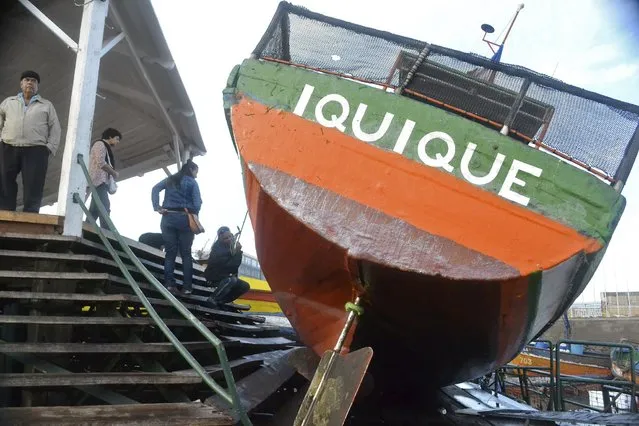 Fishermen inspect a boat washed onto a dock after a tsunami hit the northern port of Iquique April 2, 2014. An earthquake, with a magnitude of 8.2, struck off the coast of northern Chile near the copper exporting port of Iquique on Tuesday evening, killing six and triggering the tsunami that pounded the shore with 2-meter (7-foot) waves. (Photo by Hector Merida/Reuters)