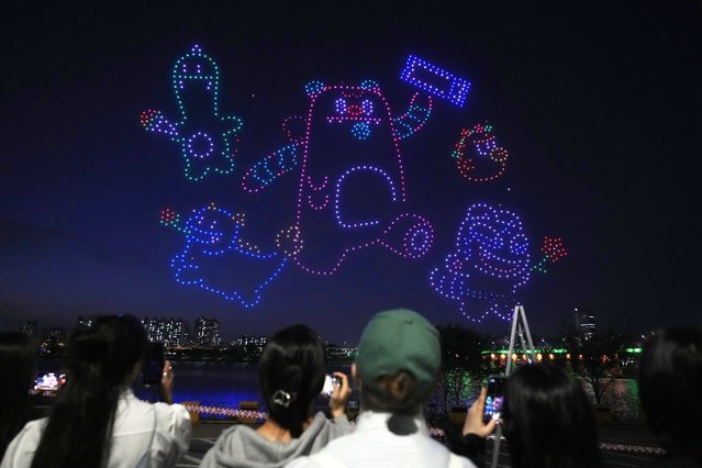 Drones light up the night sky during a drone light show at a park along the Han River in Seoul, South Korea, Saturday, April 27, 2024. A drone light show with 1,000 drones illuminated the night sky in Seoul on Saturday. (Photo by Ahn Young-joon/AP Photo)