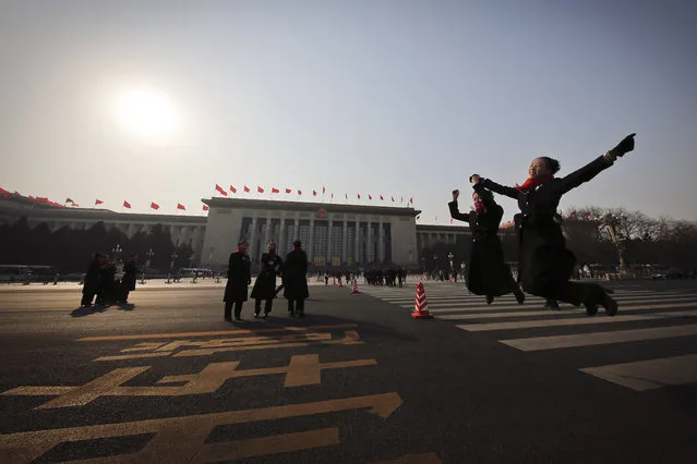 In this Friday, March 3, 2017 photo, hospitality staff jump as they pose for photographs on an empty street adjacent to the Great Hall of the People during the Chinese People's Political Consultative Conference (CPPCC) in Beijing. (Photo by Andy Wong/AP Photo)