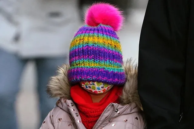 A child wears her toque pulled down over her eyes while walking in the Manhattan borough of New York City, New York, U.S., January 11, 2022. (Photo by Carlo Allegri/Reuters)