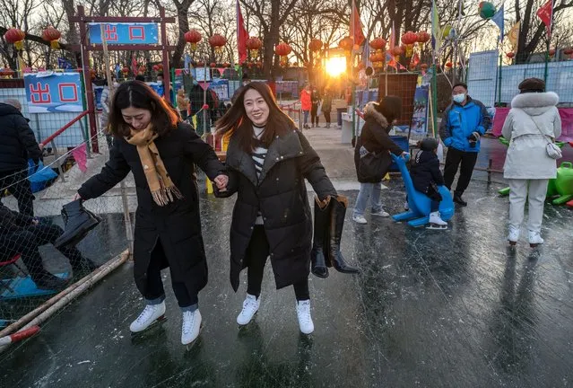 Woman take steps on skates after renting them at an outdoor rink at a local park on January 8, 2022 in Beijing, China. (Photo by Kevin Frayer/Getty Images)