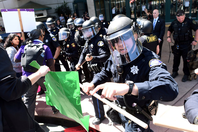 Police in riot gear hold back demonstrators against U.S. Republican presidential candidate Donald Trump outside the Hyatt hotel where Trump is set to speak at the California GOP convention in Burlingame, California, U.S., April 29, 2016. (Photo by Noah Berger/Reuters)