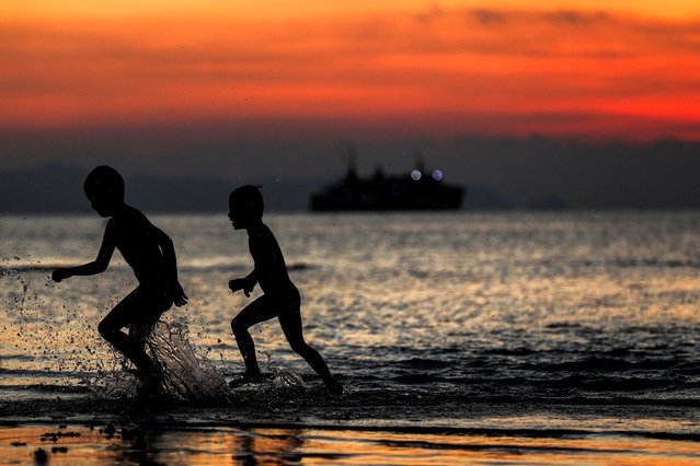 Boys splash seawater while running on the shore during the sunset along Nathon Beach in Koh Samui, Surat Thani province, Thailand on April 7, 2024. (Photo by Chalinee Thirasupa/Reuters)