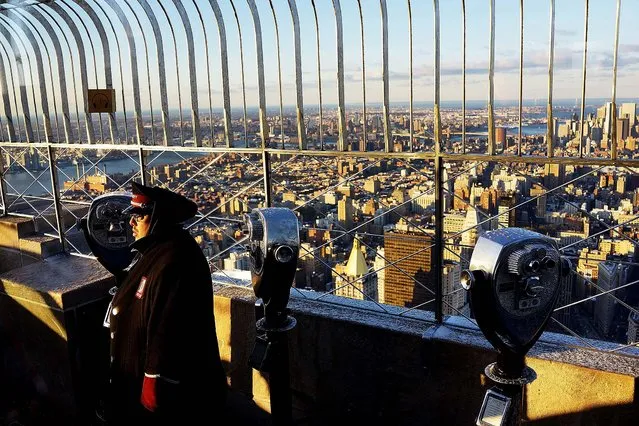 A security guard watches as Ford Motor Company Executive Chairman Bill Ford stands on top of the observation deck at the Empire State Building with the new 2015 Mustang convertible in honor of 50 years of the Ford Mustang on April 16, 2014 in New York City. (Photo by Spencer Platt/Getty Images)