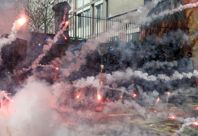 Tear gas canisters explode near riot police during clashes as part of the traditional May Day march in Paris, France, Sunday, May 1, 2016. (Photo by Michel Spingler/AP Photo)