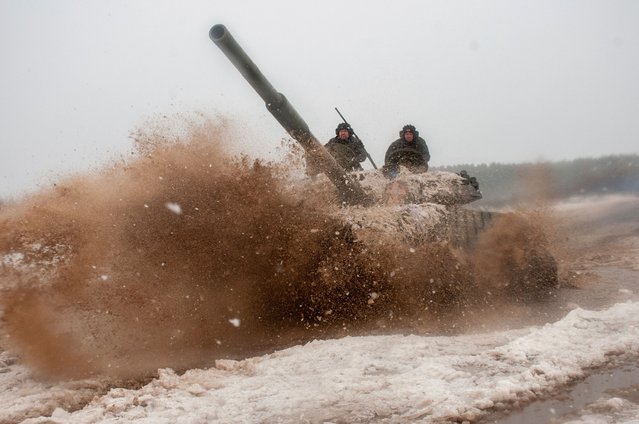 A Ukrainian tank moves during military drills close to Kharkiv, Ukraine, Thursday, February 10, 2022. Britain's top diplomat has urged Russia to take the path of diplomacy even as thousands of Russian troops engaged in sweeping maneuvers in Belarus as part of a military buildup near Ukraine. (Photo by Andrew Marienko/AP Photo)