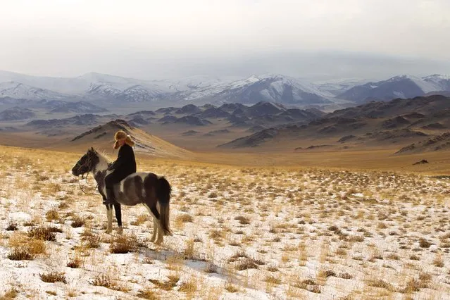 13 year old Irka Bolen with his horse. Tradition wise, when a boy turns 13, then are strong enough to hold the weight of a fully grown eagle. (Photo by Asher Svidensky/Caters News)