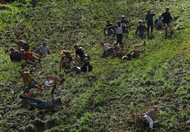 People compete in the annual Cooper's Hill Cheese Rolling competition in Brockworth, Britain on May 27, 2024. (Photo by Molly Darlington/Reuters)