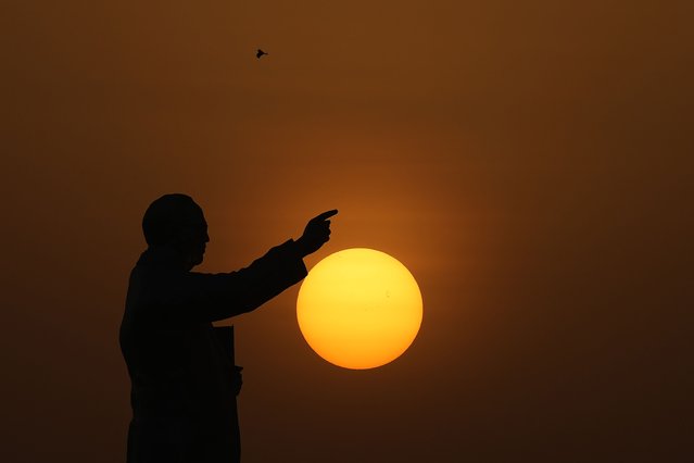 The sun sets behind a statue of Bhimrao Ramji Ambedkar, the chief architect of the Indian Constitution, in Hyderabad, India, Wednesday, May 29, 2024. (Photo by Mahesh Kumar A./AP Photo)