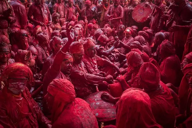 Revellers daubed in colours sing religious hymns at the Radha Rani temple during the Lathmar Holi celebrations, the Hindu spring festival of colours, in Barsana village in India's Uttar Pradesh state on March 11, 2022. (Photo by Anindito Mukherjee/AFP Photo)