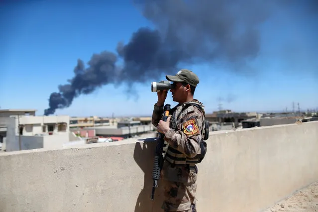 An Iraqi Counter Terrorism Services (CTS) soldier looks though binoculars during a battle between CTS and Islamic State militants in western Mosul, Iraq, April 25, 2017. (Photo by Ahmed Jadallah/Reuters)