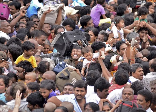 Devotees crowd to attend the Maha Pushkaralu, a Hindu festival, on the banks of river Godavari at Rajahmundry in Andhra Pradesh, India, July 14, 2015. Twenty-seven people were killed and 40 injured on Tuesday in a stampede in the Indian state of Andhra Pradesh, police said, as crowds surged to bathe in the Godavari River on the first day of the religious festival held once every 144 years. (Photo by R. Narendra/Reuters)