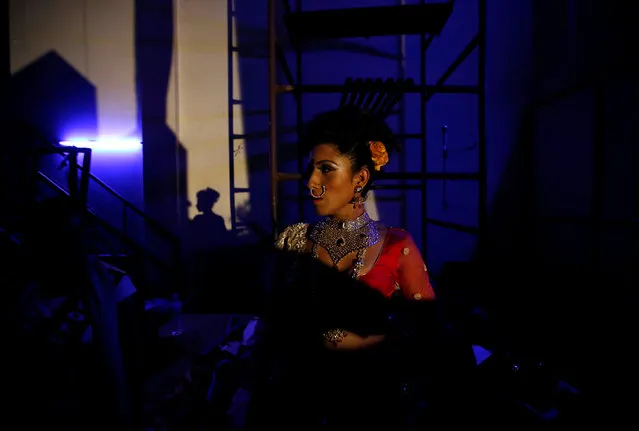 Light illuminates a contestant as she stands at the backstage of the Miss Pink Beauty Pageant in Kathmandu, Nepal, May 17, 2016. (Photo by Navesh Chitrakar/Reuters)